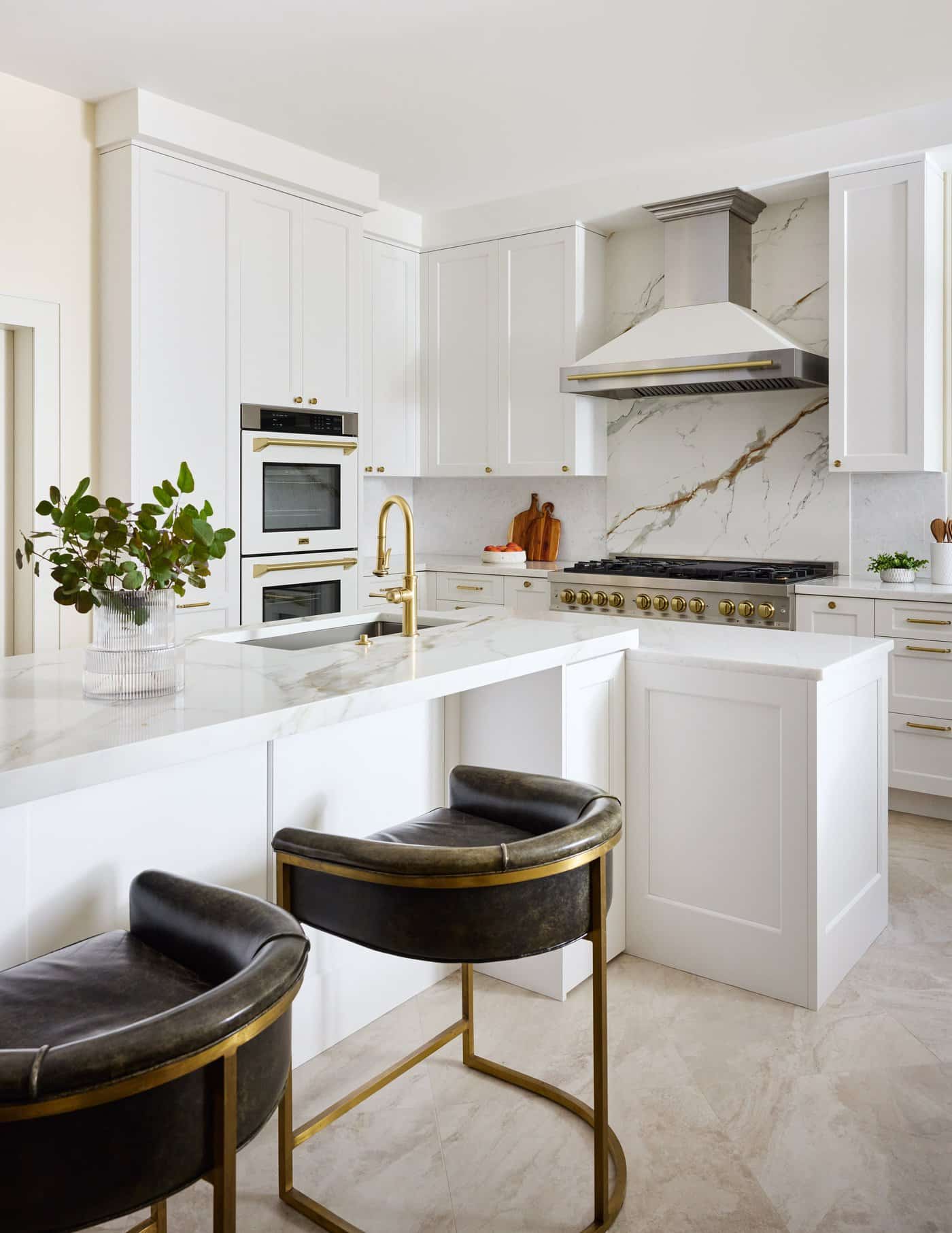 Newton Kitchens - Cutler Road kitchen island with brass faucet and leather counter stools