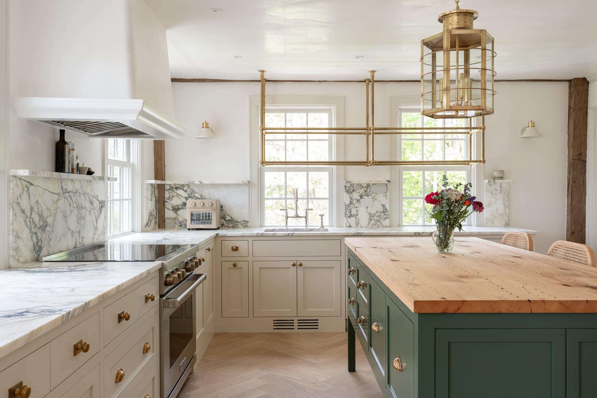 Newton Kitchens - Summer Street kitchen green island with butcher-block top and brass pot rack